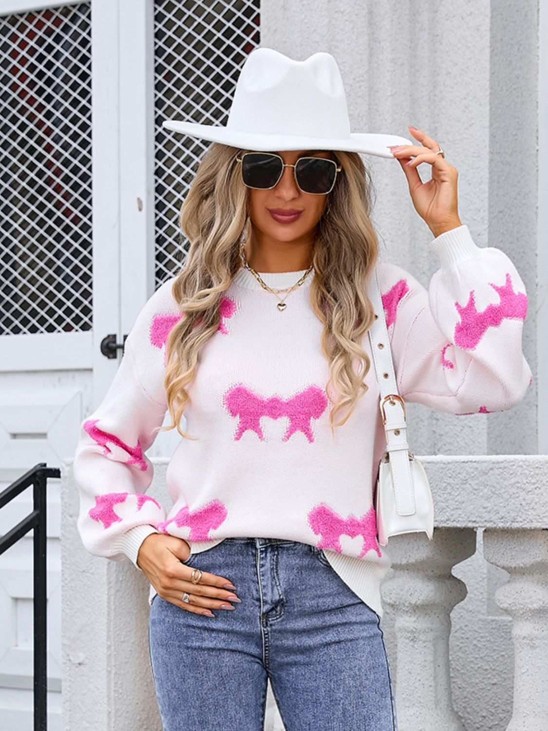 Angel Wings Bow Round Neck Dropped Shoulder Sweater in white with pink motifs, moderate stretch, worn with jeans and white accessories.