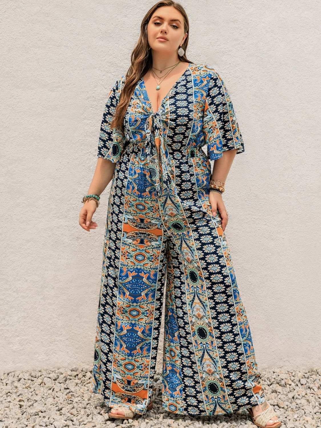Plus size printed wide leg jumpsuit with half sleeves and tie detail.