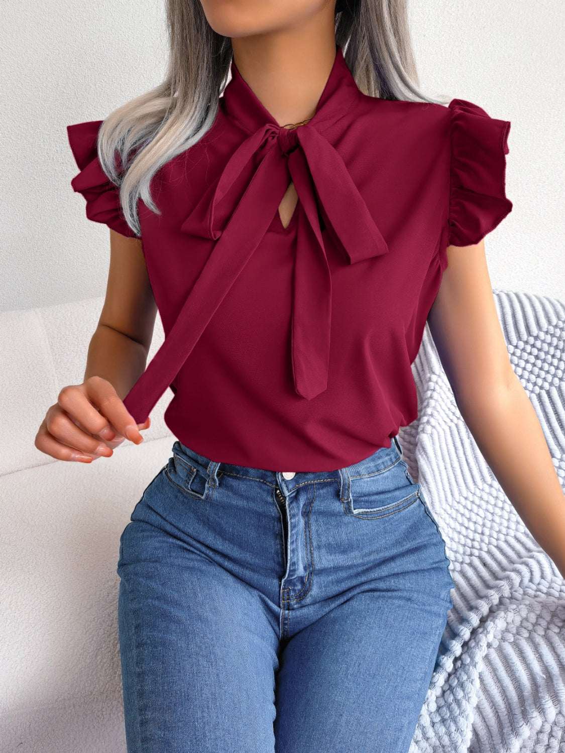 Tie neck cap sleeve blouse in burgundy, slightly stretchy polyester blend.