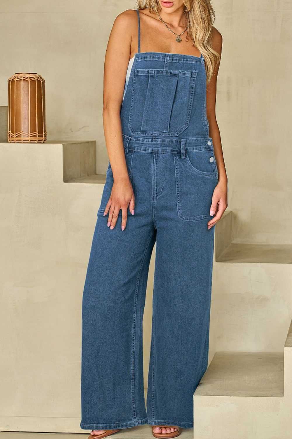 Adjustable tie straps wide leg denim overalls with pockets and buttoned details.