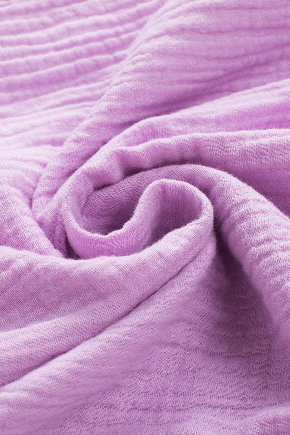 Soft purple cotton fabric with textured folds, perfect for a dropped shoulder V-neck blouse.