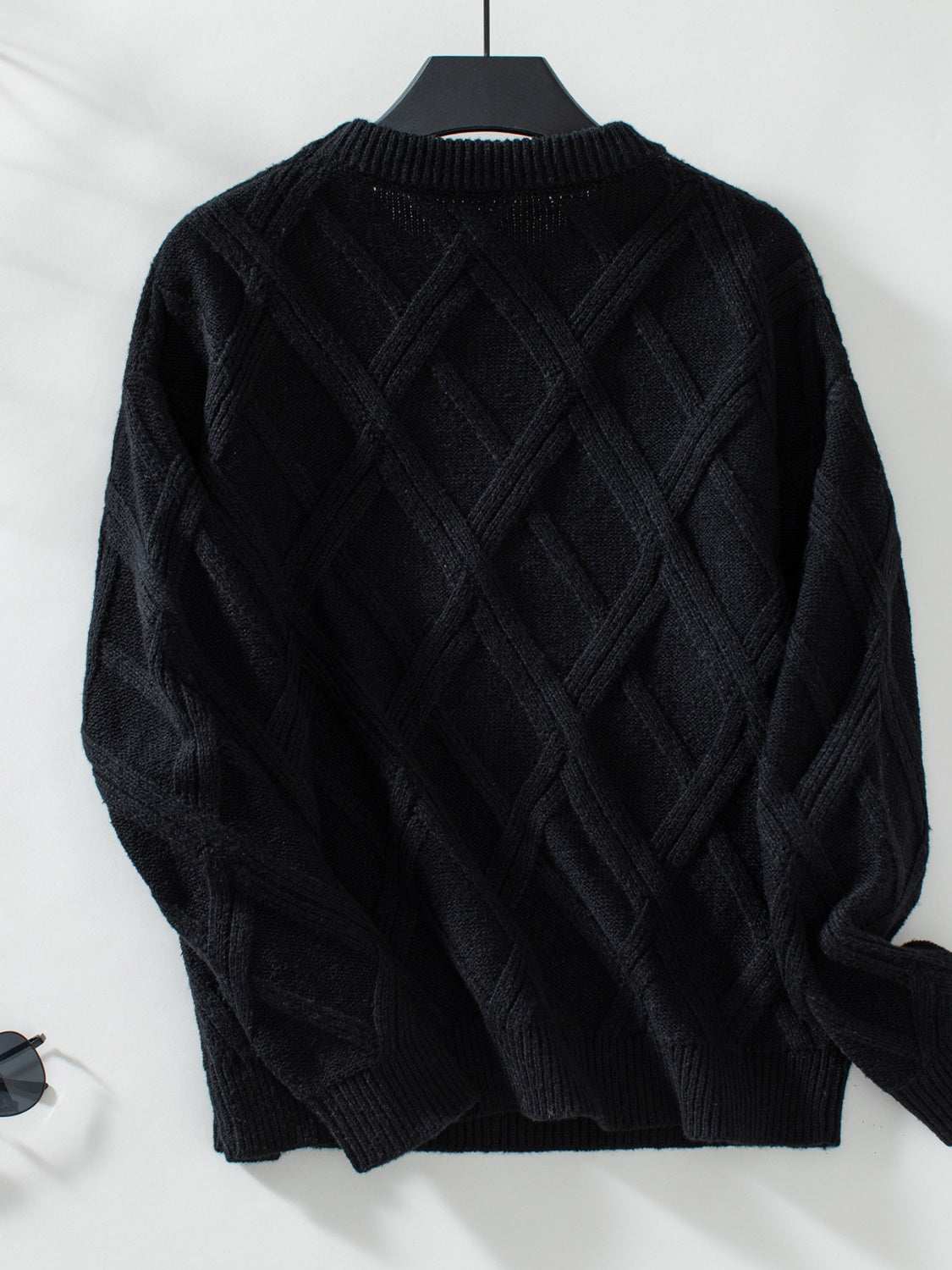 Geometric round neck long sleeve sweater in black with diamond pattern.