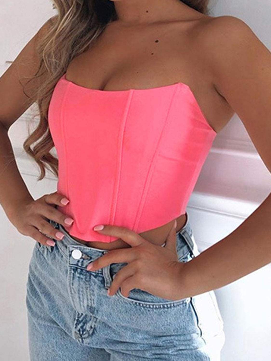 Neon pink tube cropped top with slight stretch, styled casually with jeans.