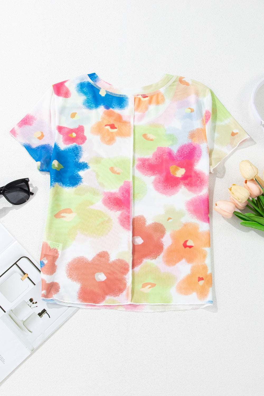 Printed round neck short sleeve blouse with colorful floral design.