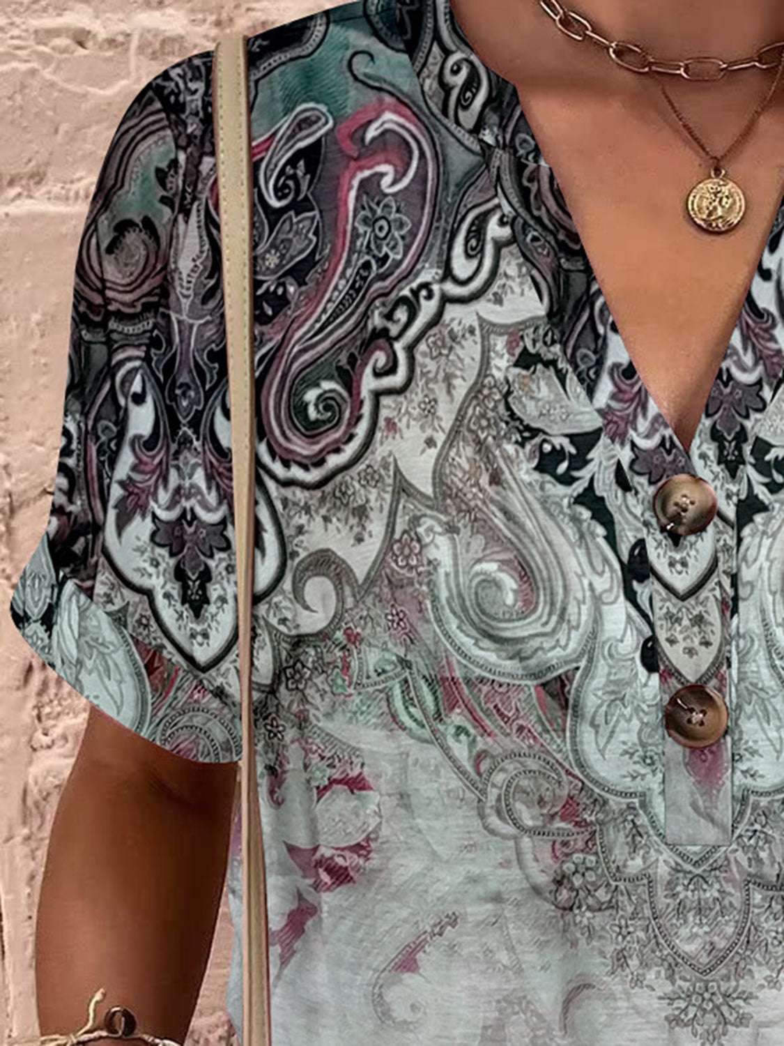 Full size printed notched short sleeve blouse with button details and intricate pattern.