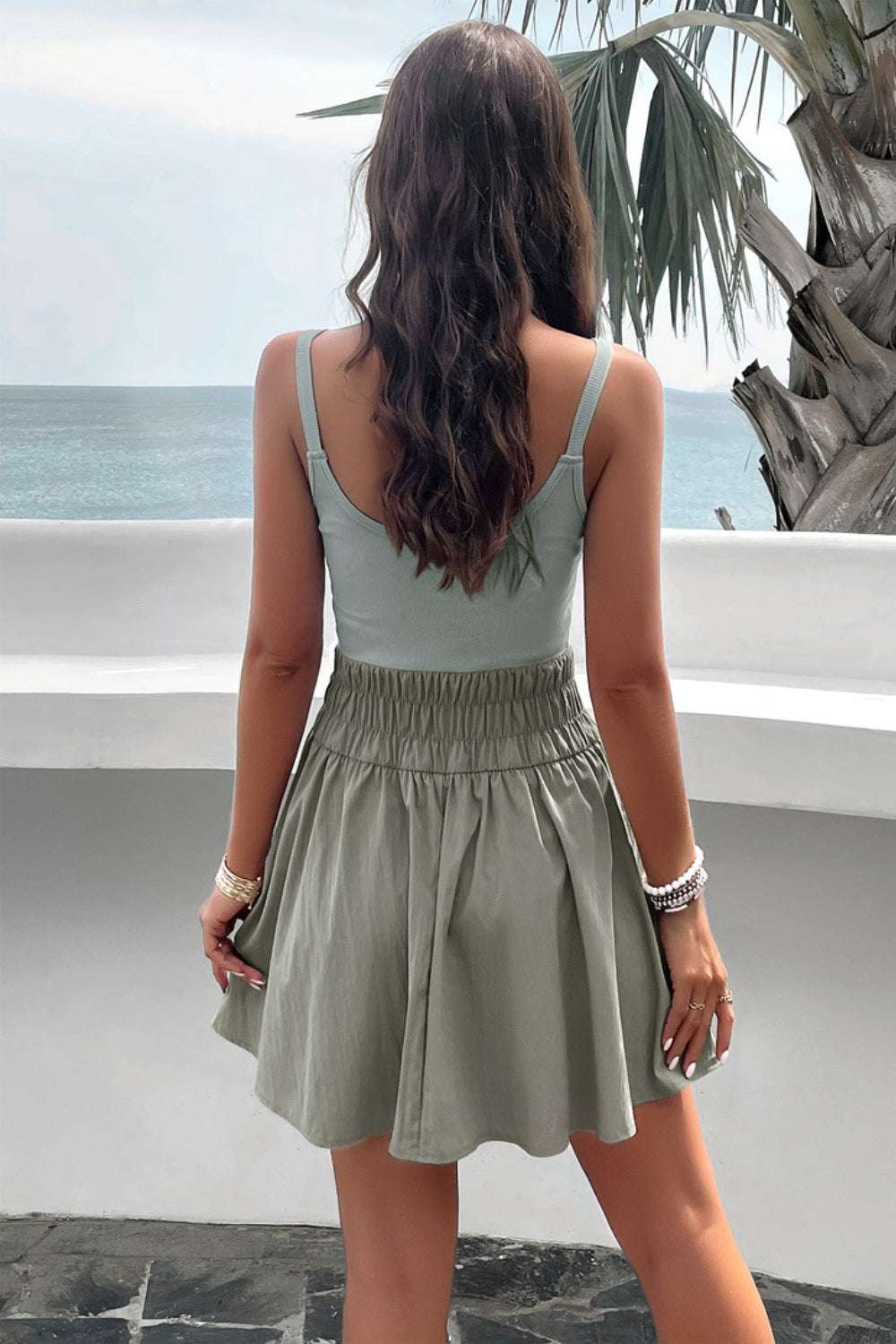 Devine Smocked Scoop Neck Mini Cami Dress, sleeveless with smocked waist, viewed from the back.