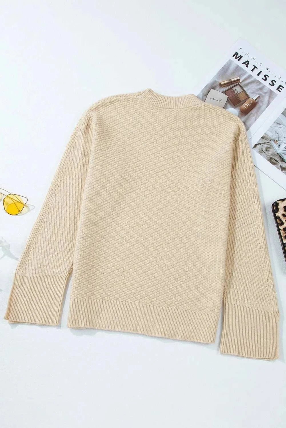 Textured round neck long sleeve sweater in beige with slit and slightly stretchy material.