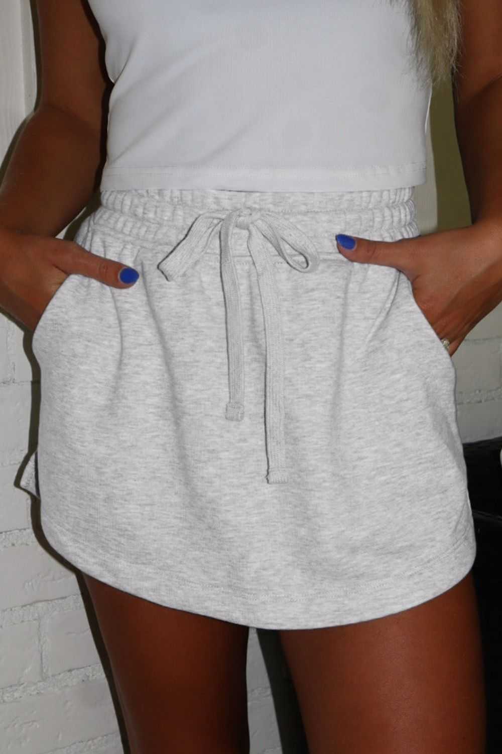 French Terry drawstring mini skort with pockets, featuring a comfortable fit, in light gray shade.
