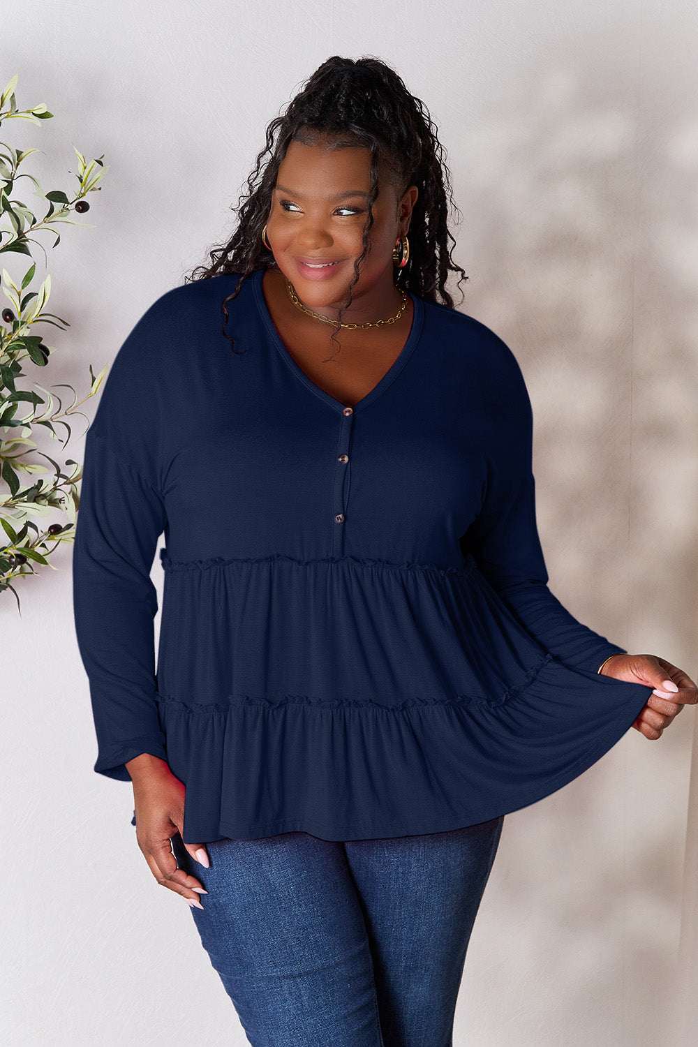 Long sleeve navy blouse with half button detail and ruffle hem.