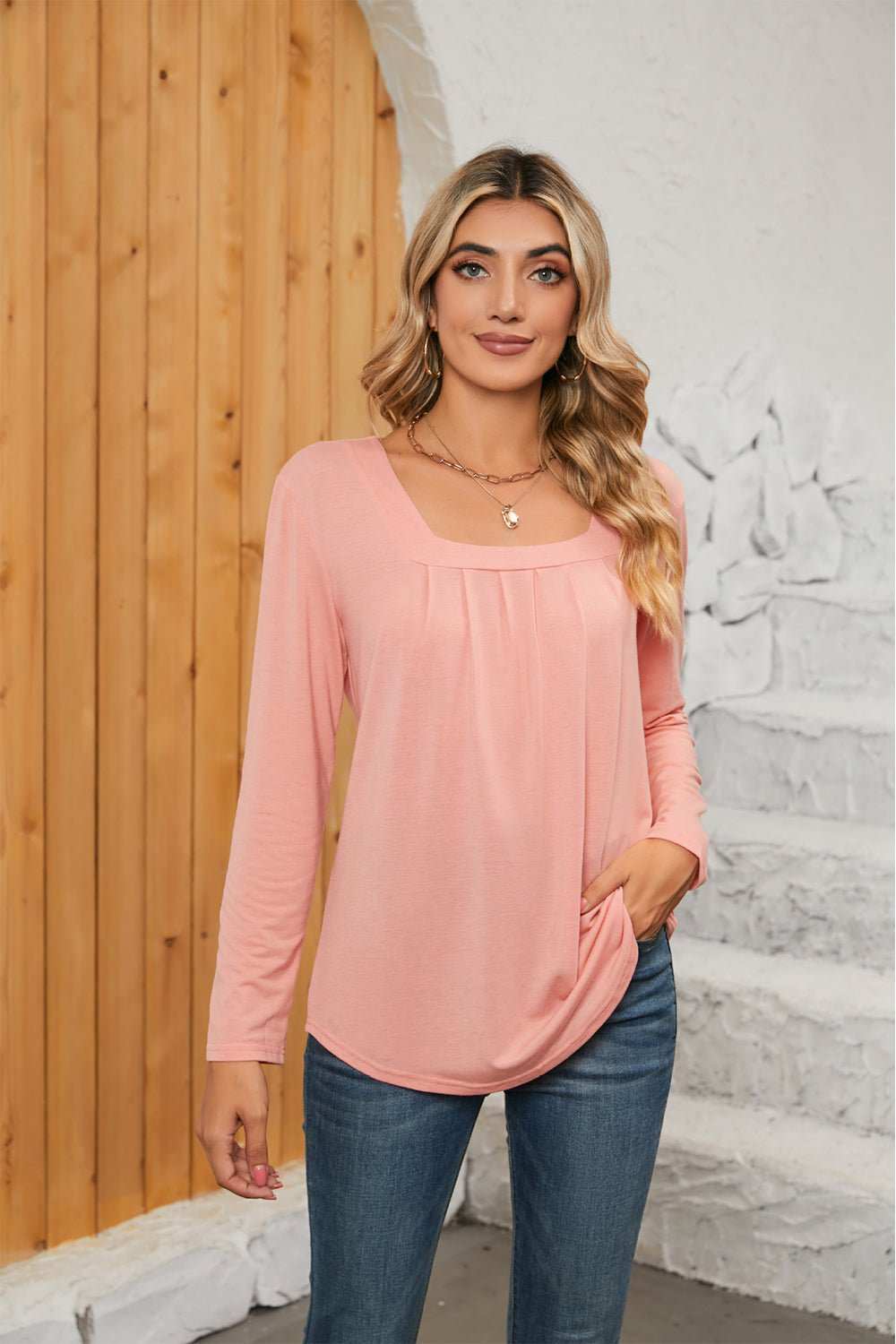 Woman wearing pink square neck long sleeve t-shirt with casual jeans standing indoors