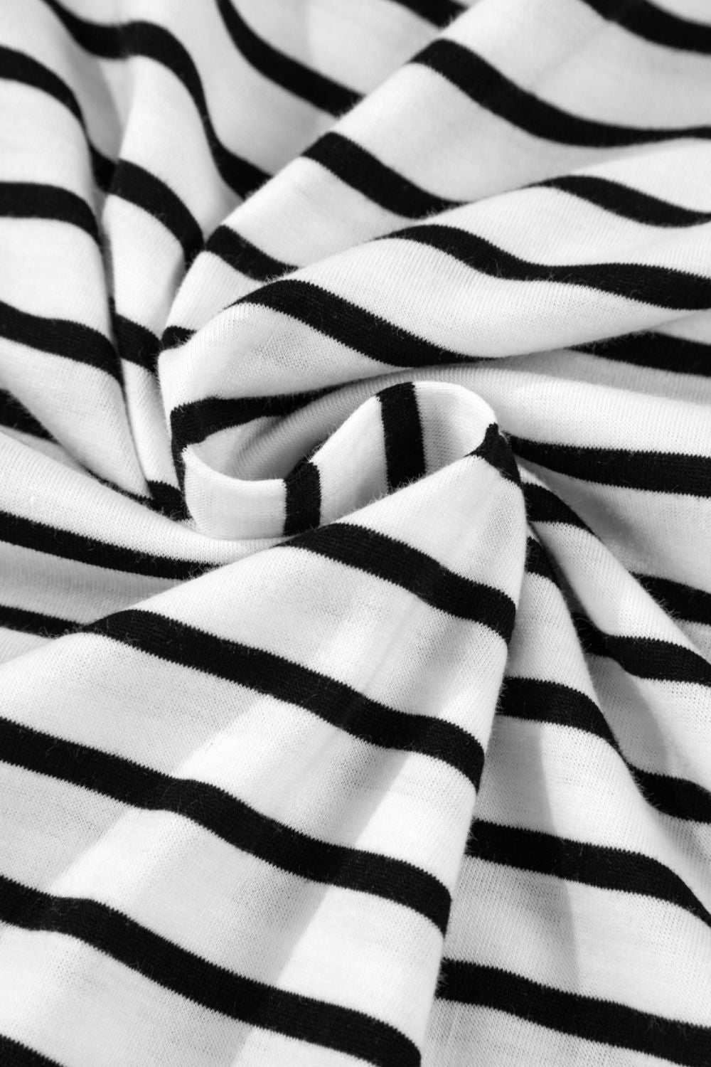 Close-up of black and white striped fabric on a half sleeve top.