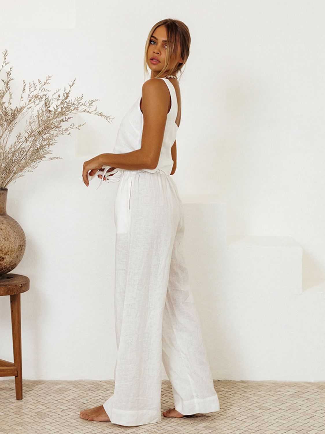 Square neck sleeveless top and pants set in white cotton, women’s two-piece outfit with tied and ruffled features.