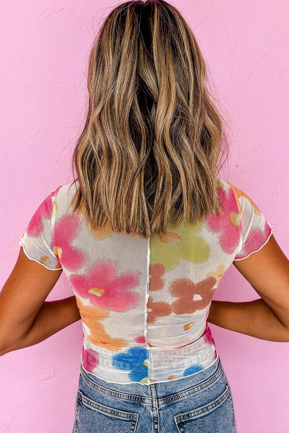 Printed round neck short sleeve blouse with colorful floral design.