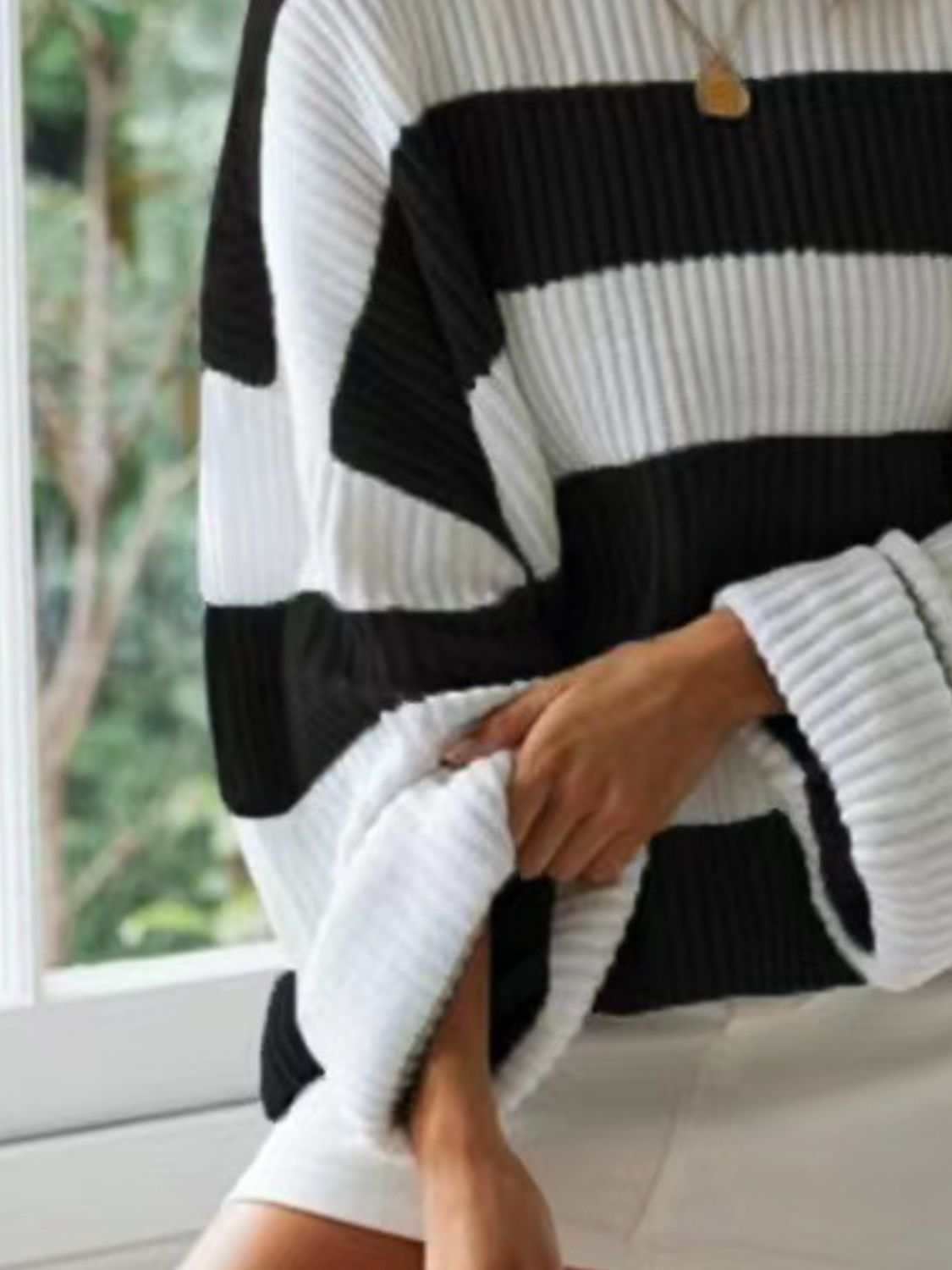 Round neck long sleeve sweater with black and white stripes, slightly stretchy polyester material.