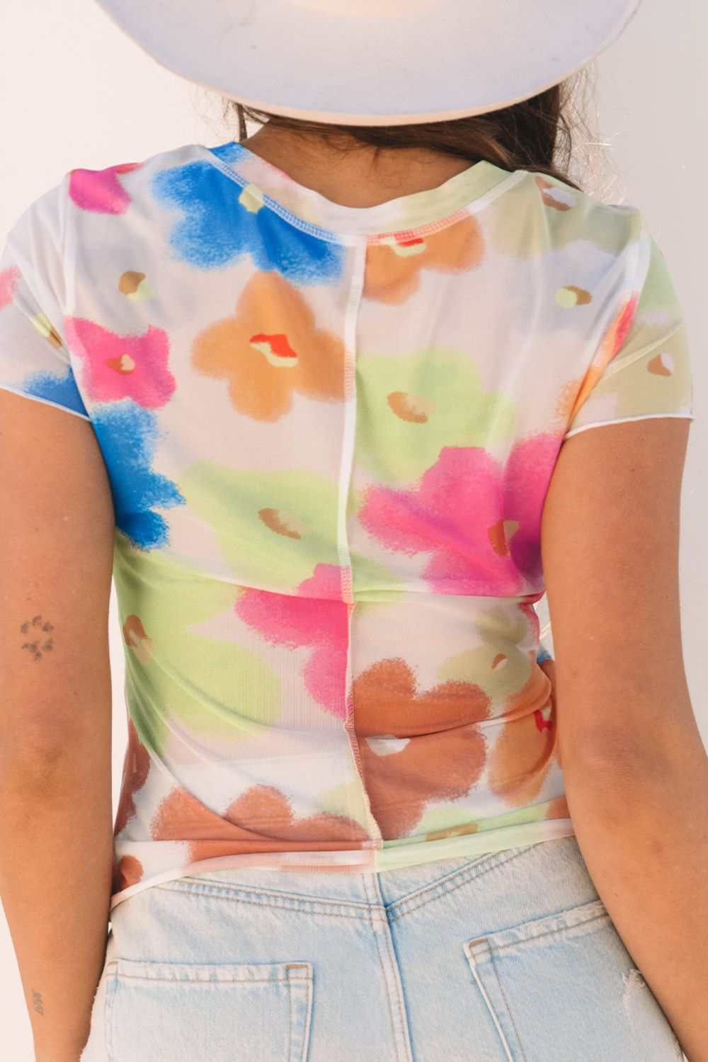 Printed round neck short sleeve blouse with colorful floral design.