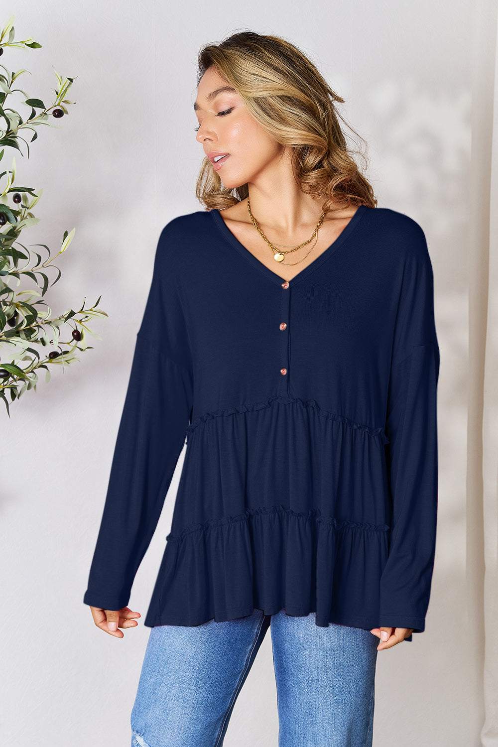 Half button long sleeve ruffle hem blouse in navy, opaque with slight stretch.