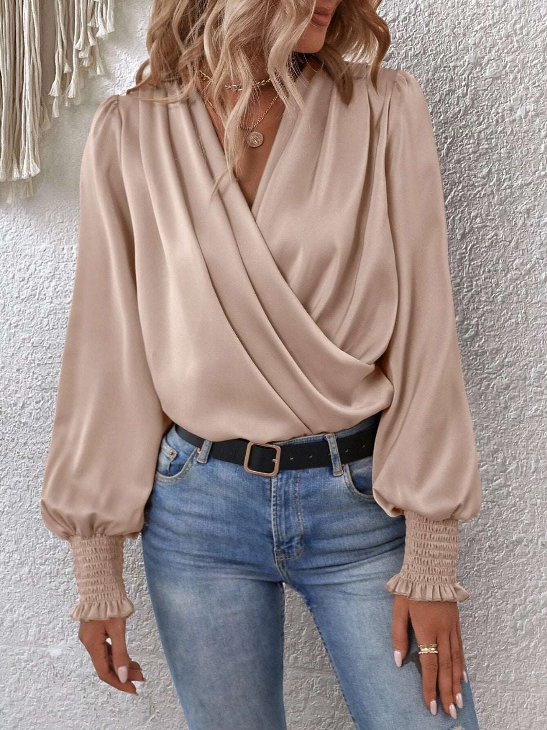 Surplice Smocked Lantern Sleeve Blouse in beige with long sleeves and a draped neckline.