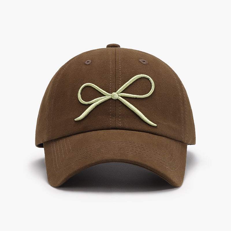 Bow embroidered cotton baseball cap with adjustable fit and curved brim.
