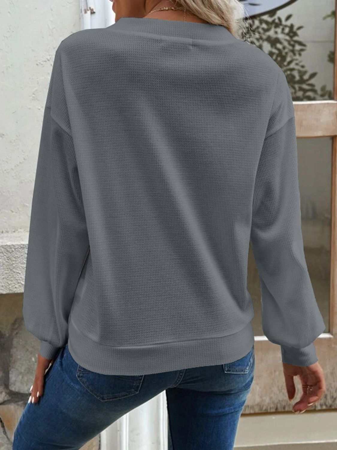 Solid gray V-neck dropped shoulder blouse with waffle-knit texture and long sleeves.