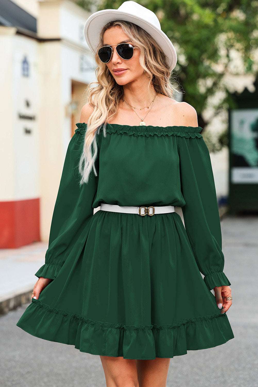 Frill off-shoulder flounce sleeve dress in green with white belt, worn by woman with sunglasses and hat.