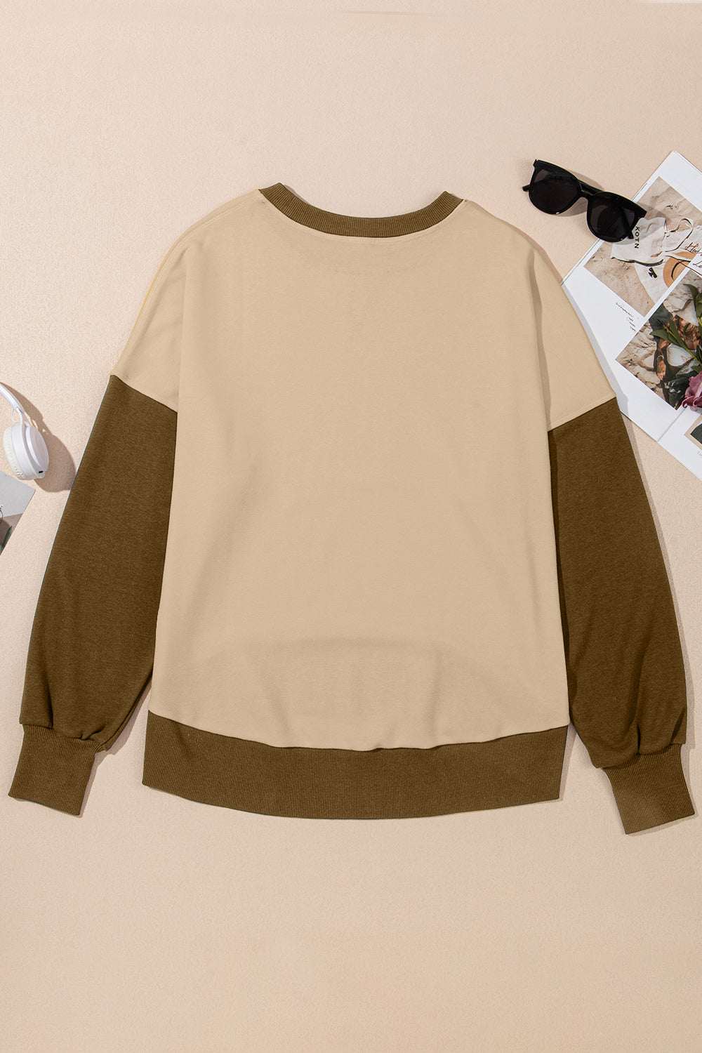 Contrast round neck long sleeve sweatshirt in beige and brown tones displayed flat with accessories.