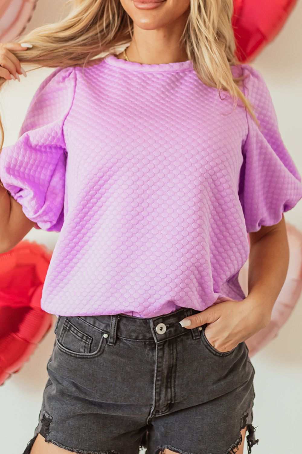 Textured round neck puff sleeve blouse in light purple, worn by a model with black shorts.
