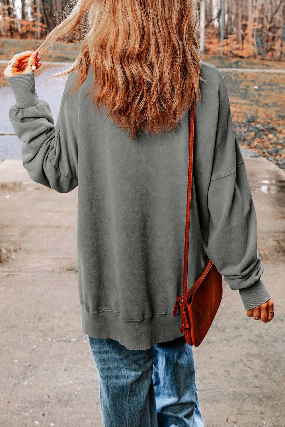 Casual solid color dropped shoulder blouse with round neck and long sleeves.