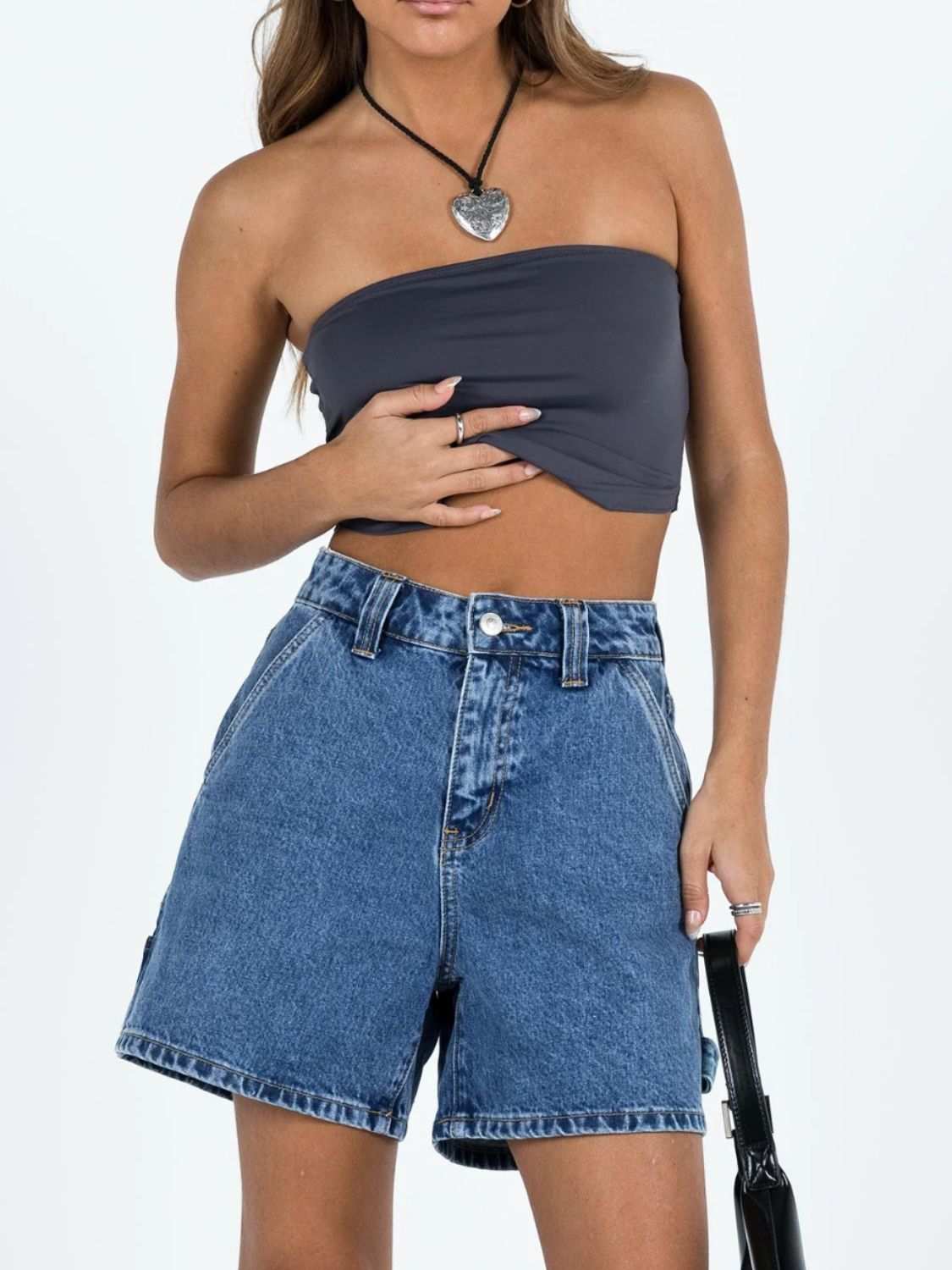 Washed high rise denim shorts with pockets, paired with a strapless top.