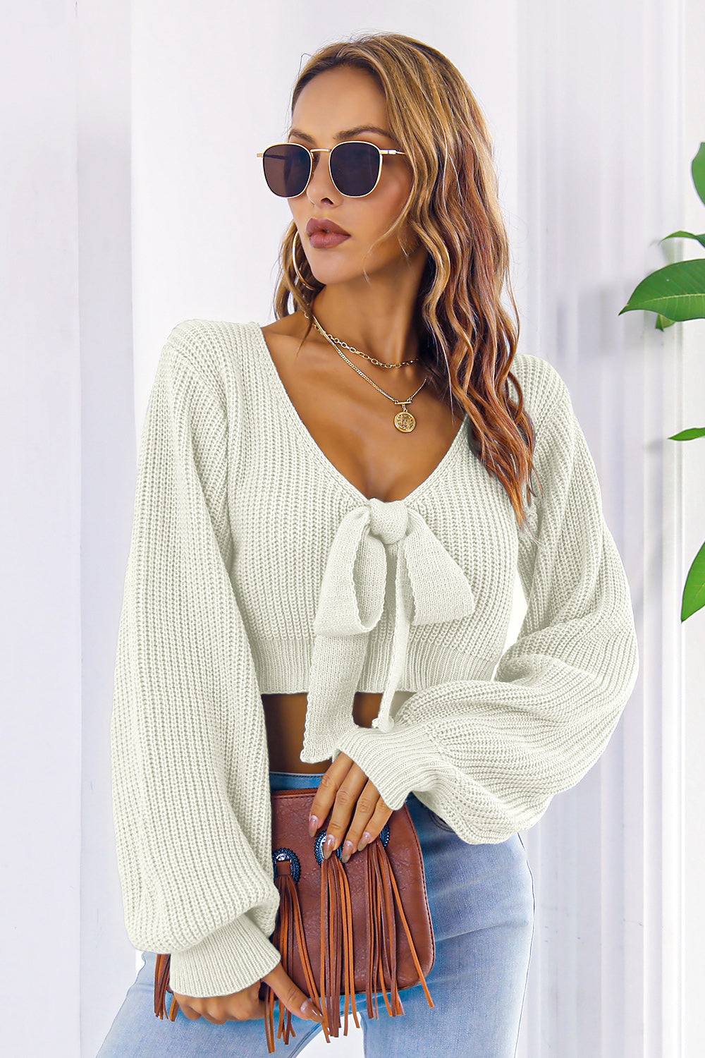 Bow V-Neck Long Sleeve Cropped Sweater in white, featuring a tied front and slightly stretchy acrylic material.