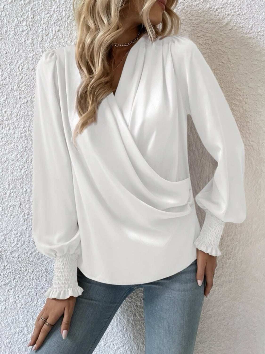 Surplice smocked lantern sleeve blouse with opaque polyester fabric.