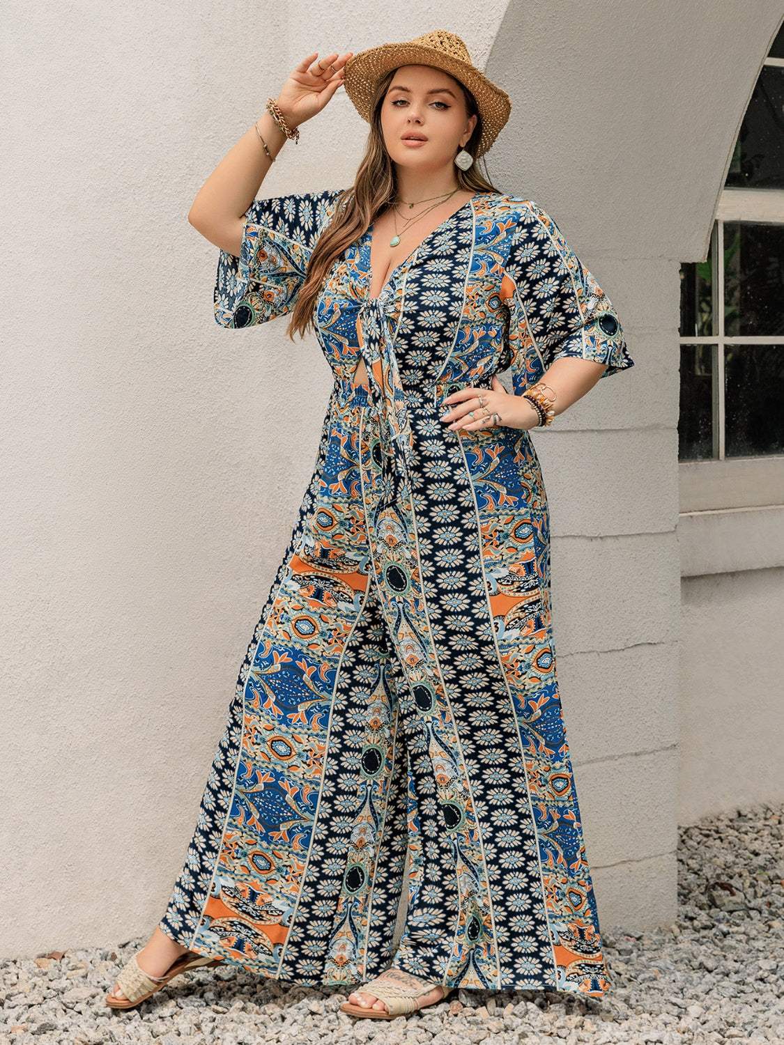 Plus size printed half sleeve wide leg jumpsuit in blue and orange viscose fabric.