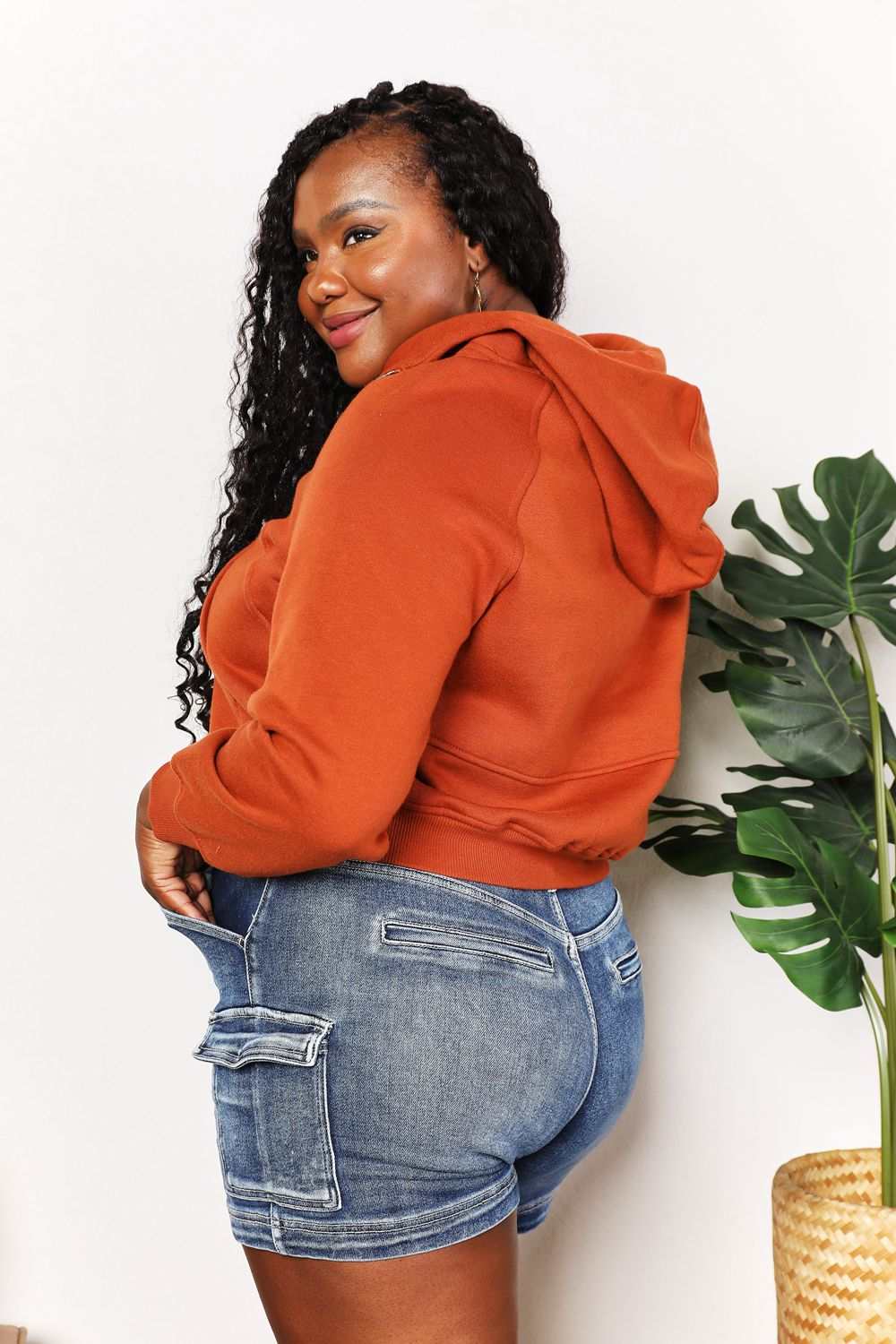 Solid-colored cropped half-zip hoodie with long raglan sleeves.