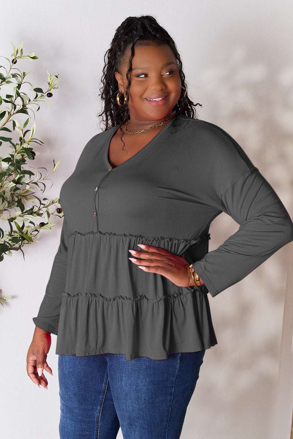 Half button long sleeve ruffle hem blouse in gray, worn by model.