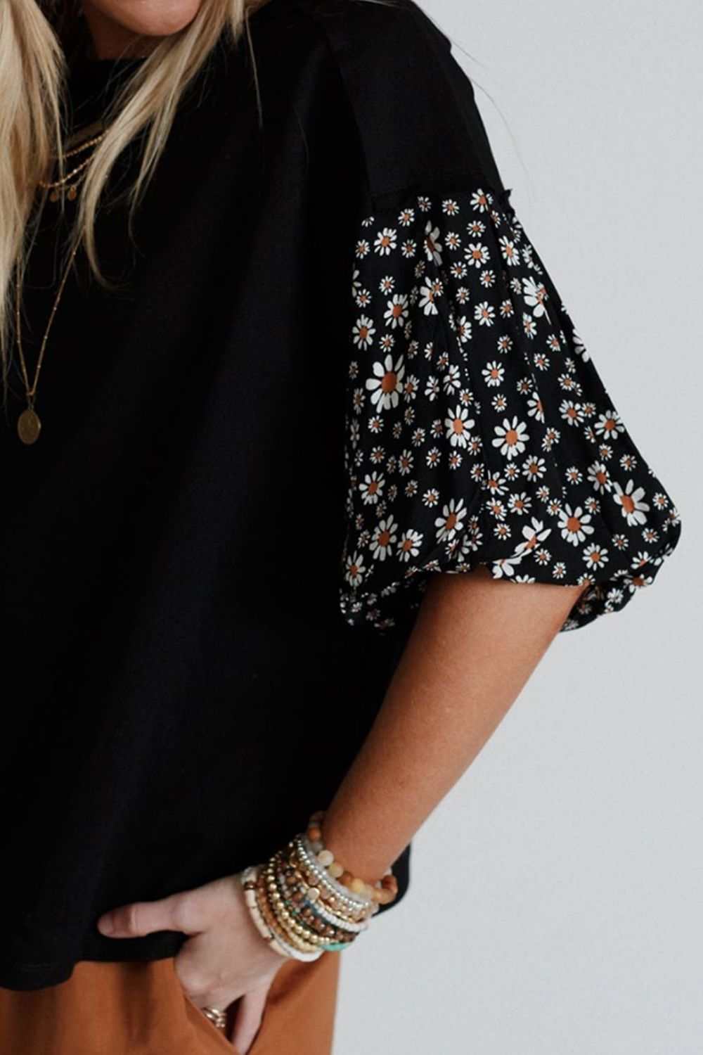 Contrast floral puff sleeve oversized top with black body and floral patterned sleeves.
