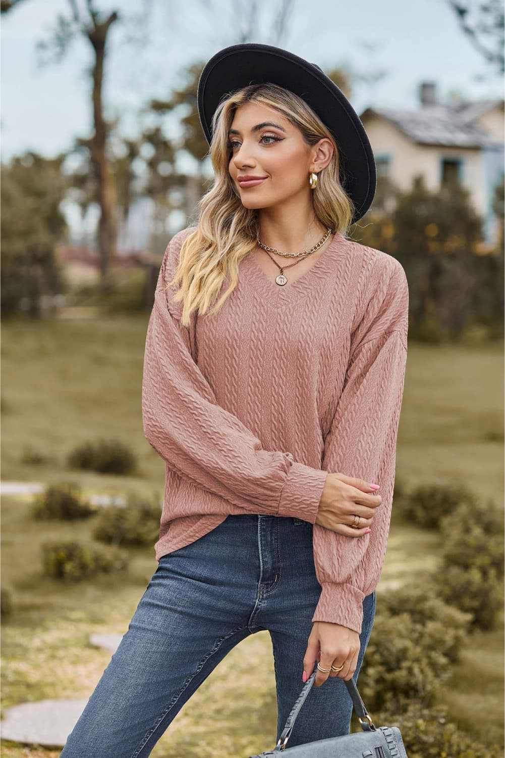 V-Neck Dropped Shoulder Blouse with long sleeves, casual style in solid pattern, worn by woman outdoors.