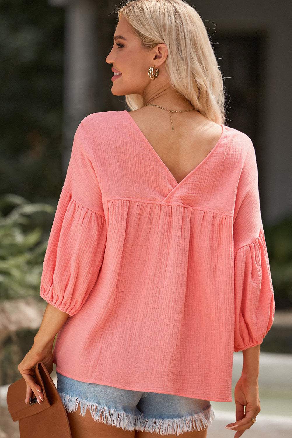 Dropped shoulder V-neck blouse in solid pink with long sleeves.
