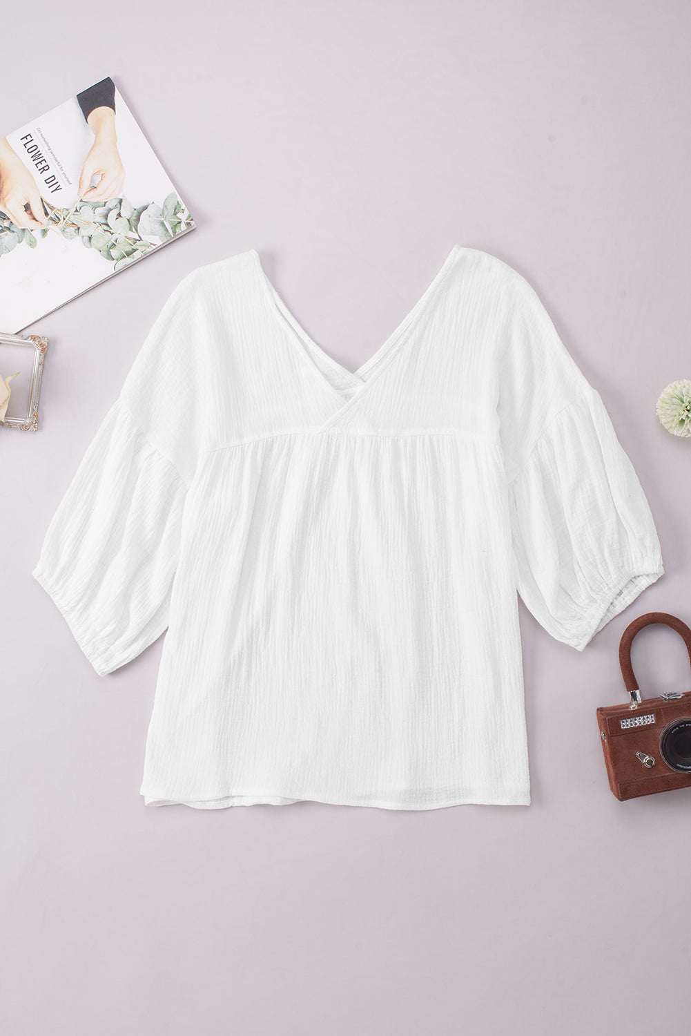 Dropped shoulder V-neck blouse with long sleeves, solid white, casual style made of 100% cotton.
