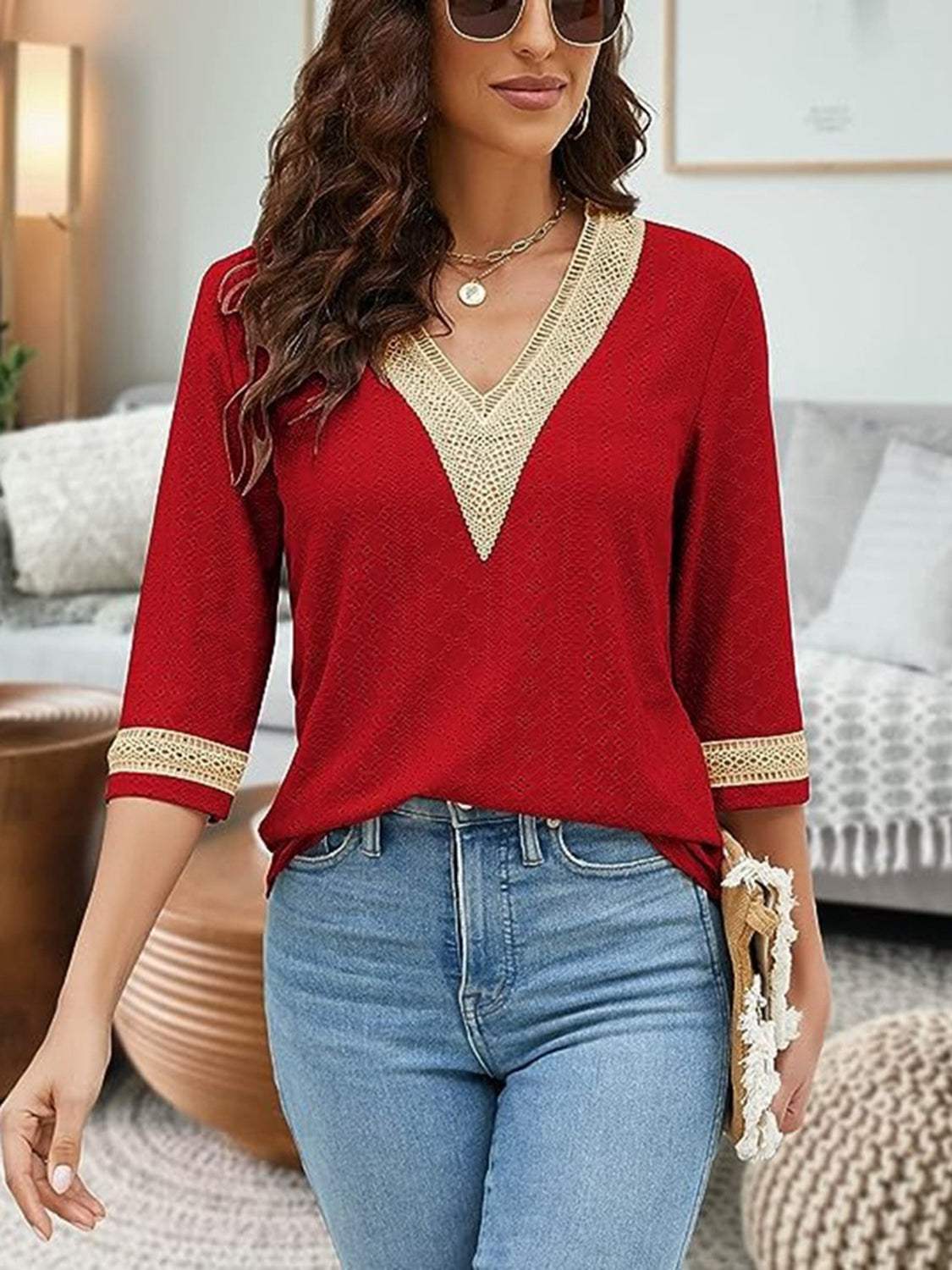 V-Neck Eyelet Blouse in red with gold trim, basic style, worn by woman with curly hair.