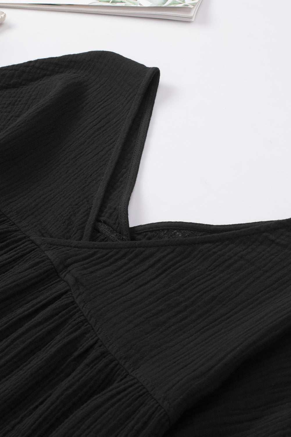 Black dropped shoulder V-neck blouse in solid pattern with long sleeves and casual style.