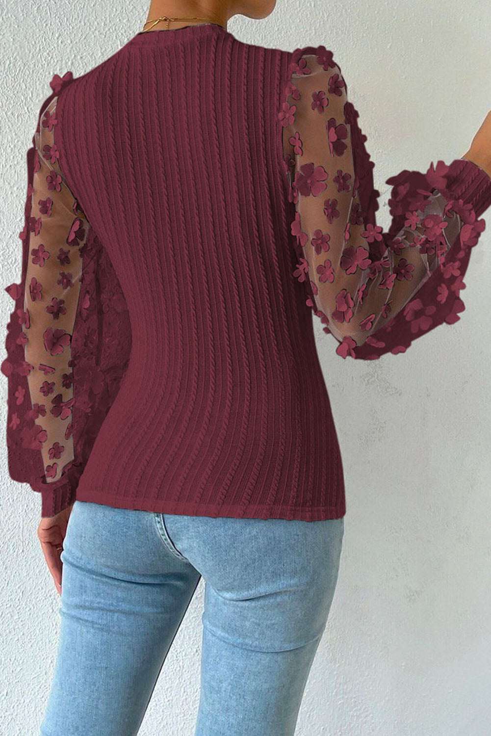 Textured applique long sleeve blouse with cable-knit design and floral accents, round neck, casual style.