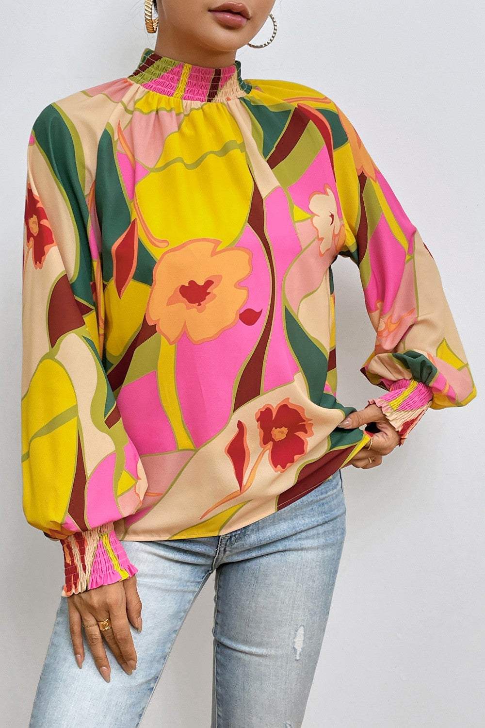 Floral smocked lantern sleeve mock neck blouse with vibrant colors and opaque fabric.