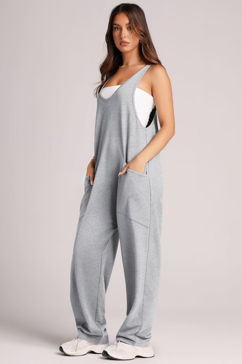 Woman wearing grey Lovelet V-Neck wide strap pocketed overalls with white sneakers