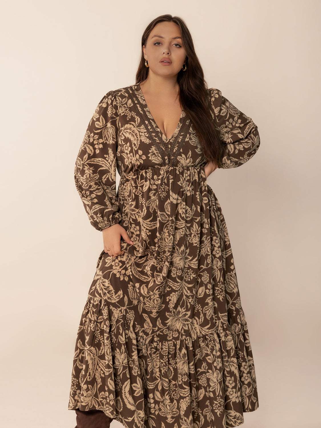 Plus size printed V-neck balloon sleeve maxi dress in brown, featuring ruched design and floral pattern.