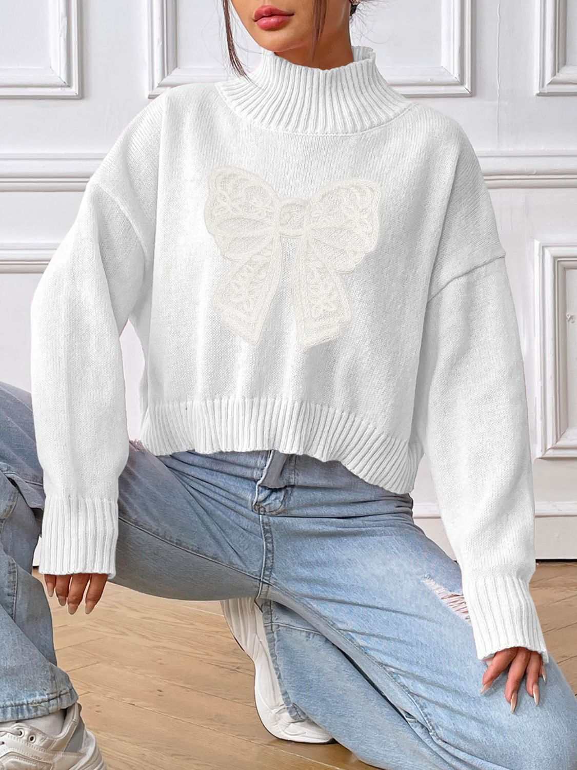 Bow turtleneck long sleeve sweater in white, featuring a basic, slightly stretchy design with a bow detail, made from 100% polyester.