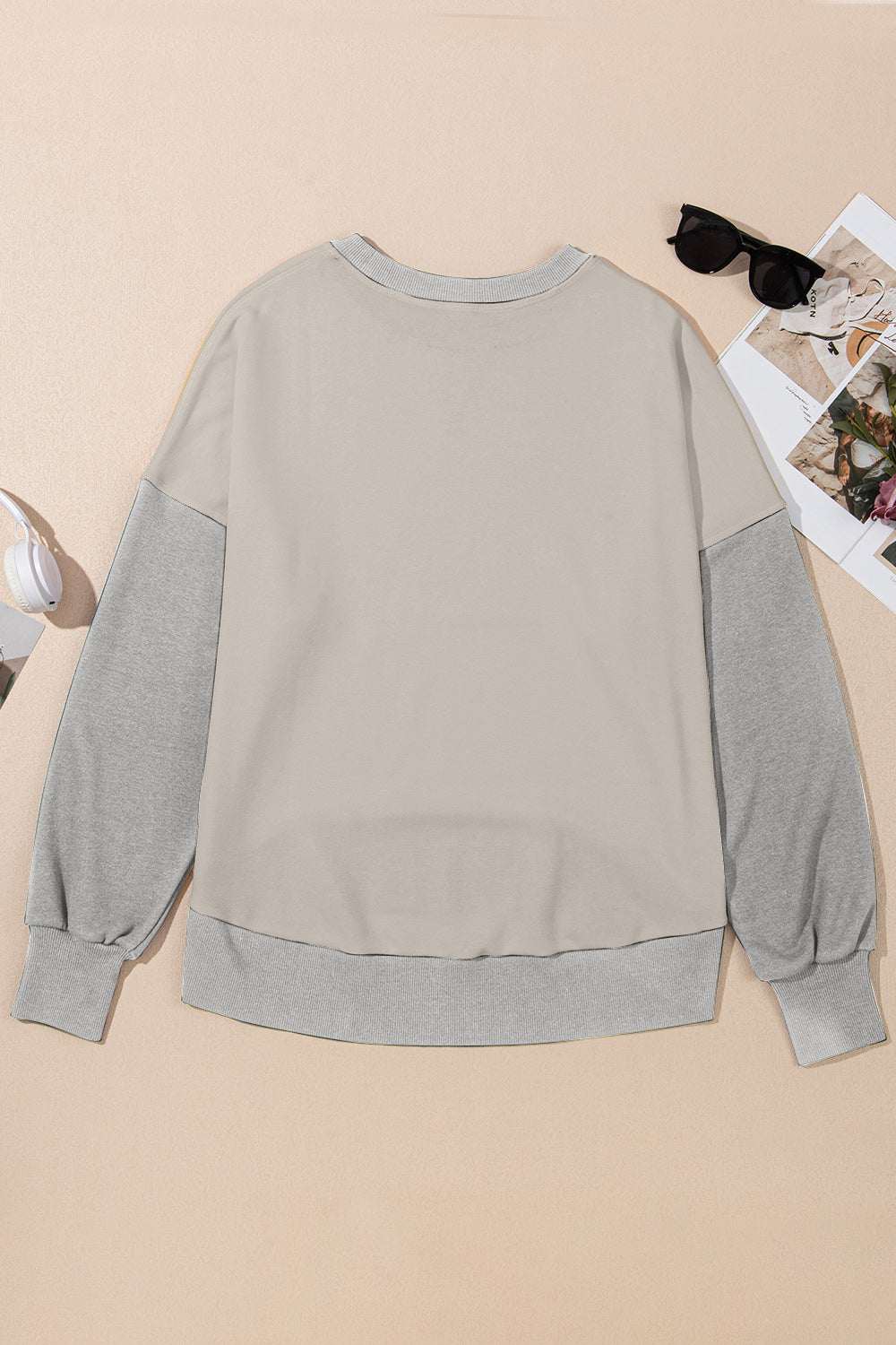 Contrast round neck long sleeve sweatshirt in gray and beige, laid flat with accessories.