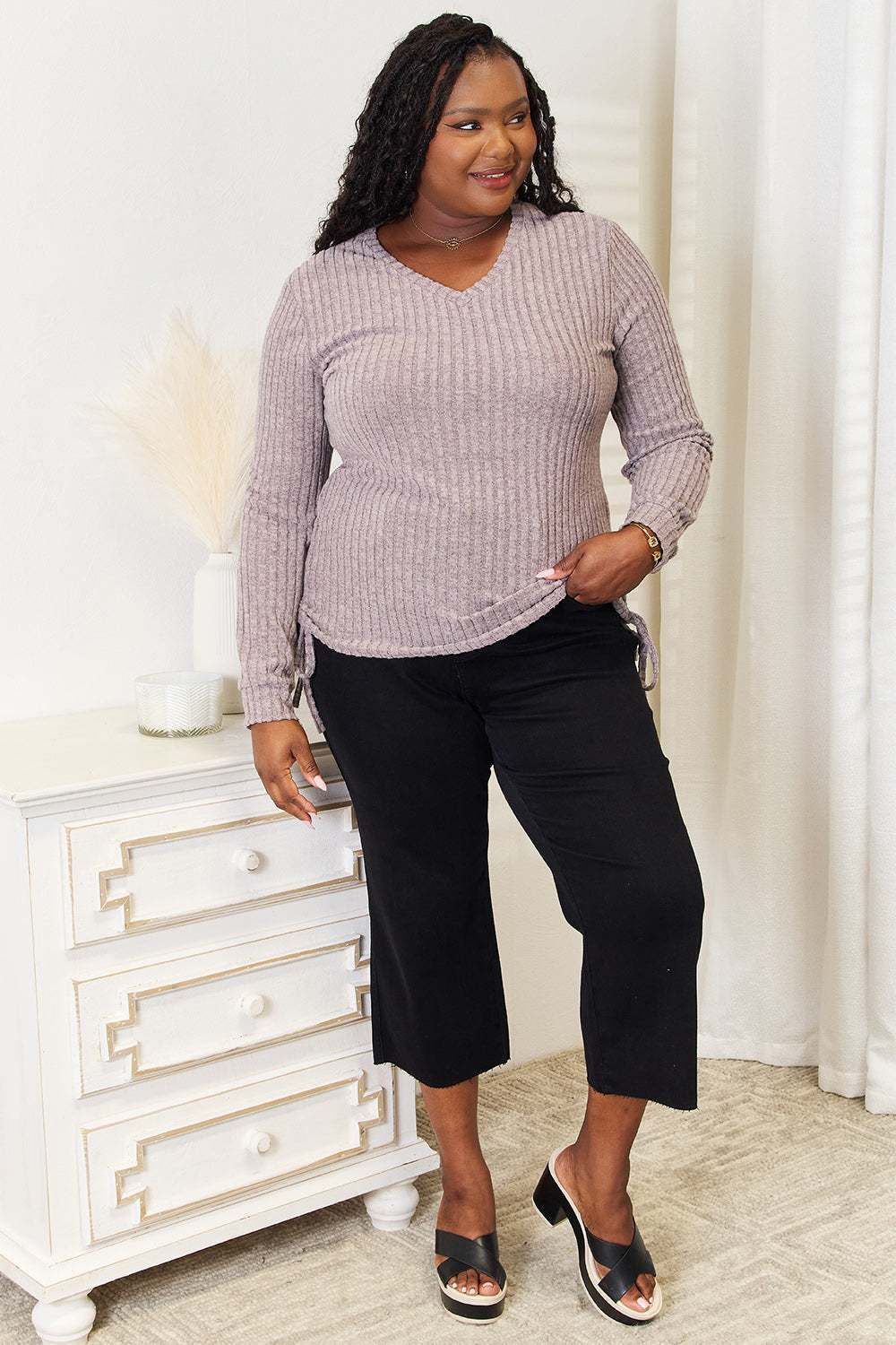 Curvy model wearing a drawstring ribbed long sleeve t-shirt, paired with black pants, showcasing a trendy and versatile casual outfit.