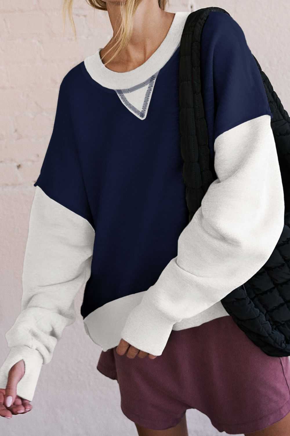 Contrast round neck long sleeve sweatshirt with white and navy blue design.