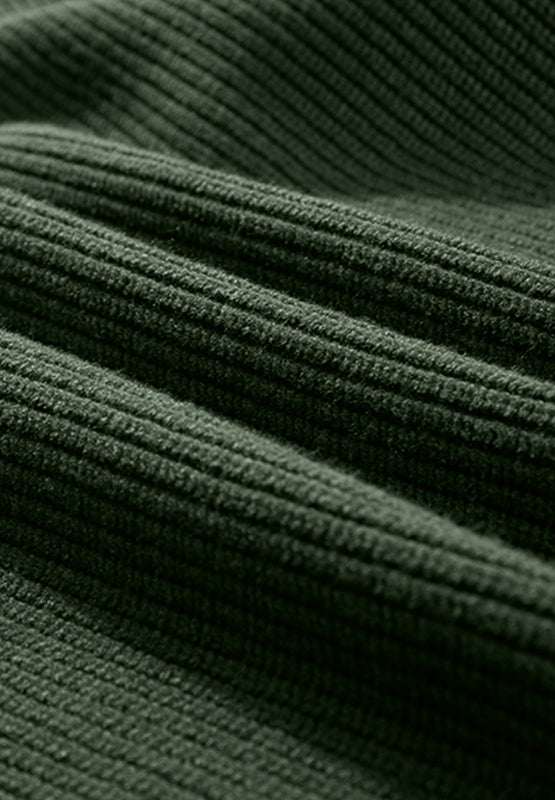 Close-up of a ribbed knit green fabric for a V-neck long sleeve sweater.