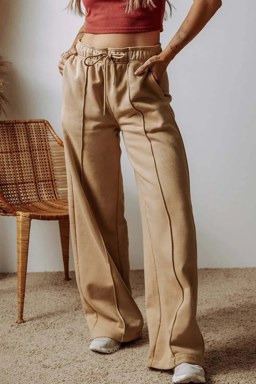 Drawstring wide leg pants with pockets in beige fabric.