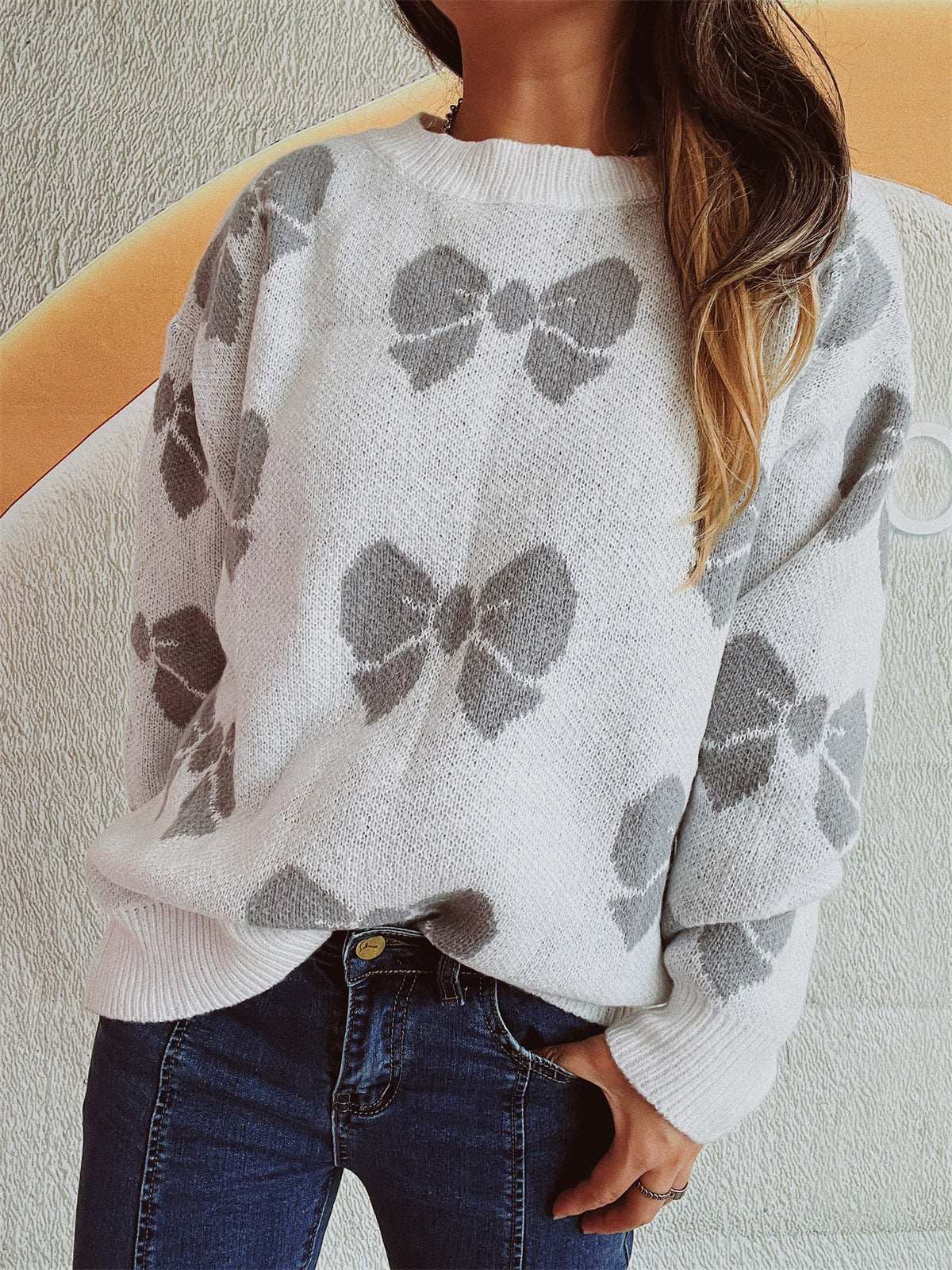 Bow round neck dropped shoulder sweater with gray bow design on white fabric, moderate stretch.